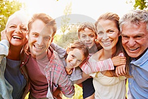 Multi-generation family having fun together outdoors photo