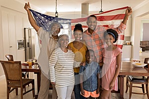 Multi-generation family holding an American flag at home