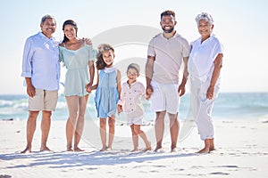 Multi generation family on holding hands while standing on the beach together. Mixed race family with two children, two