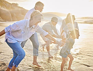 Multi generation family holding hands and walking along the beach together. Caucasian family with two children, two