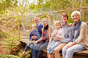 Multi-generation family portrait on a bridge in a forest