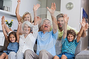 Multi-generation family raising their arms