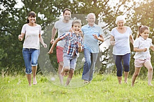 Multi Generation Family Running Across Field Together