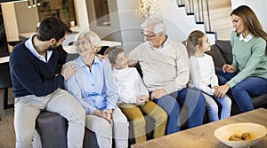 Multi generation family sitting together on the sofa at home and watching TV