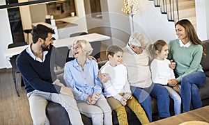 Multi generation family sitting together on the sofa at home and watching TV