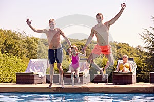 Multi-Generation Family On Summer Holiday Jumping Into Swimming Pool