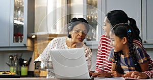 Multi-generation family using laptop in kitchen 4k