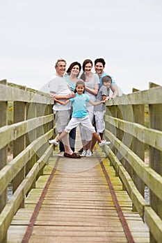 Multi Generation Family Walking Along Wooden Bridge