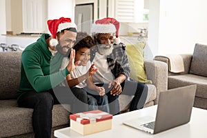 Multi-generation family waving while having video chat on laptop at home