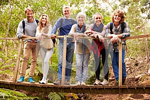 Multi-generation family on wooden bridge in forest, portrait