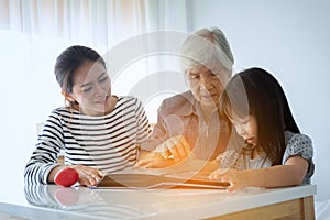 Multi-generation Female members of a family looking at a photo a