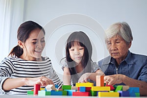 Multi-generation Female members of a family play wooden cubes co