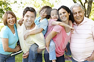 Multi Generation Hispanic Family Standing In Park