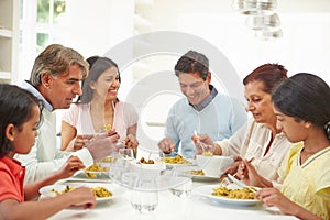 Multi Generation Indian Family Eating Meal At Home