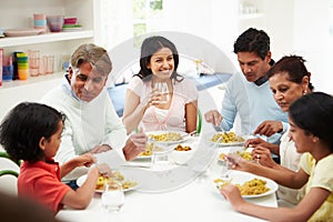 Multi Generation Indian Family Eating Meal At Home