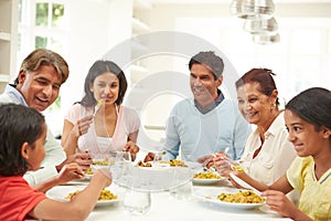 Multi Generation Indian Family Eating Meal At Home
