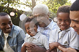 Multi generation male family members gathered in a garden