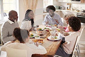 Multi generation mixed race family eating their Sunday dinner together at home, elevated view