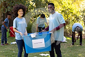 Multi-generation people collecting garbage with a couple holding a box written Donation