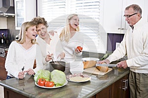 Multi-generational family making lunch in kitchen photo