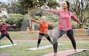 Multi generational people doing yoga class keeping at city park - Focus on right girl face