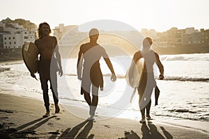 Multi generational surfer friends having fun on the beach after surf session - Main focus on faces