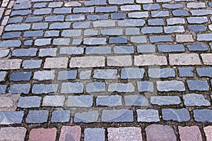 Multi-hued bricks make up a varied pattern where many feet have trod.