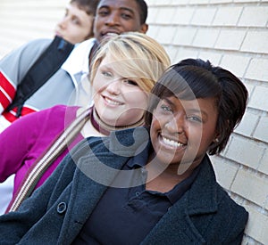 Multi-racial college students against a brick wall