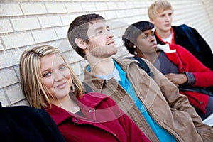 Multi-racial college students against a brick wall