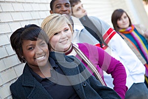 Multi-racial college students against a brick wall