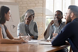 Multi racial employees listening ceo at group meeting