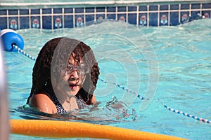 Multi Racial tween girl in pool with goggles on