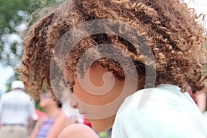 Multi Racial tween girl in profile with lots of curly hair