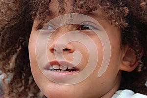 Multi Racial tween girl in profile with lots of curly hair