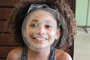 Multi Racial tween girl with swim goggles on head