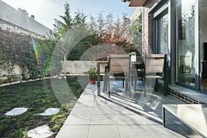 multi-storey detached house with an outdoor dining table with slate paths attached to the property\'s perimeter hedge