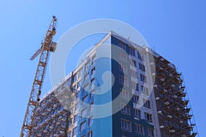 Multi-storey house under construction next to the construction crane.