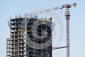 Multi-storey residential building with tower crane during construction stop and mortgage crisis