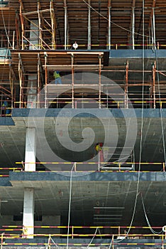 Multi-story building construction site with workers on scaffolds