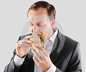 Multi tasking businessman eats and works photo