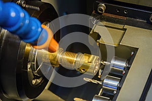 The multi tasking CNC lathe machine swiss type drilling the brass fitting parts