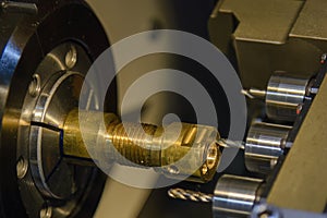 The multi tasking CNC lathe machine swiss type drilling the brass fitting parts