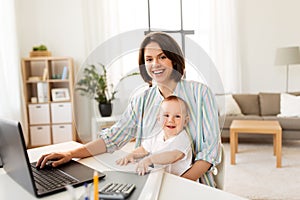 Working mother with baby boy and laptop at home