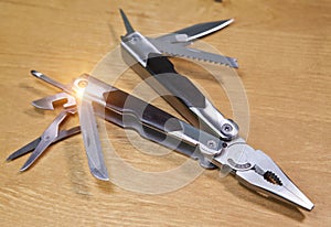 The multi tool is pocket marching with the displayed edges and tools on a wooden table