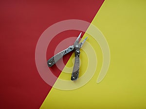 Multi tool with steel handles on a white colored background. Top view
