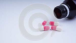 multi vitamins supplement spilled from bottle, on white background