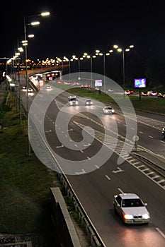 Multiband highway in big city with going cars in night. Cars drive on highway