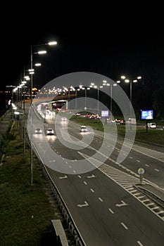 Multiband highway in big city with going cars in night. Cars drive on highway