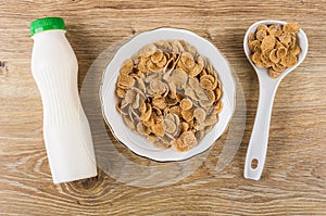 Multicereal flakes in bowl, spoon with flakes, napkin, yogurt