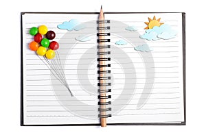 Multicolor candy draw line for balloon put on open notebook
